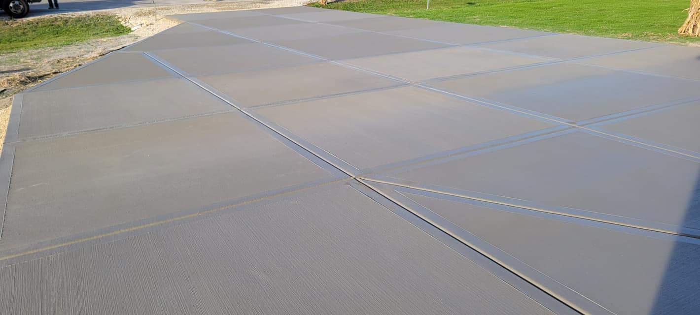 Freshly poured concrete driveway with control joints to prevent cracking.